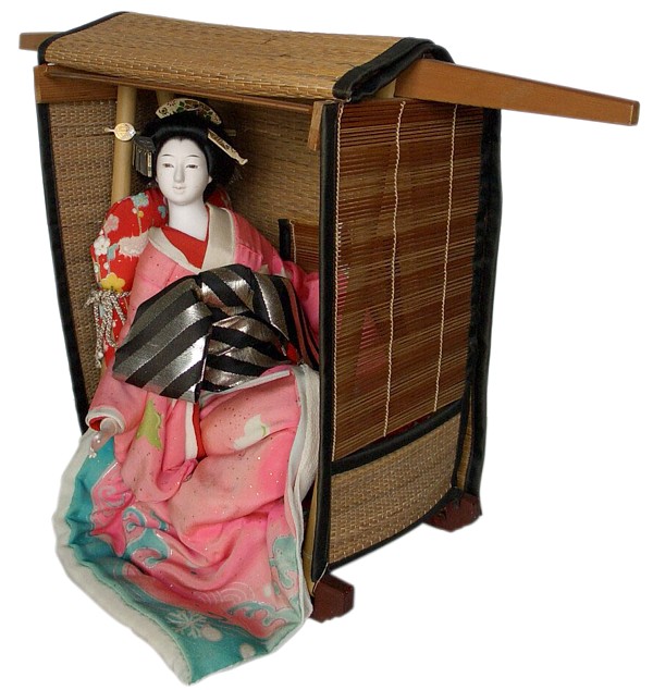  japanese antique doll of a geisha sitting  in straw taxi-cab