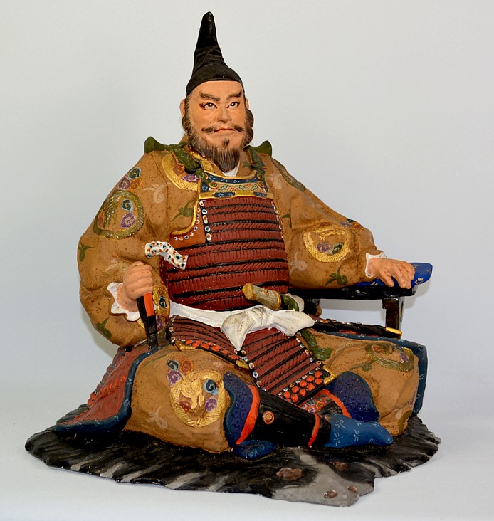 samurai warrior lord sitting on bearskin rug, Japanese hakata doll
