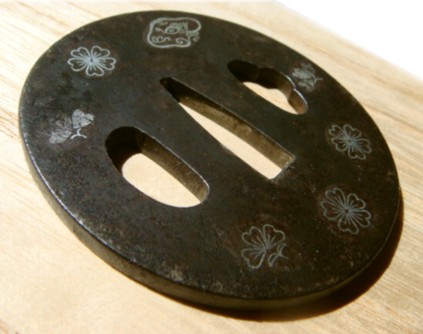 кованная цуба японского меча с изображением цветов сакуры и Львая Будды